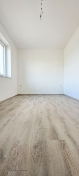 Prázdná místnost s podlahou s dřevěným dekorem v rodinném domě.