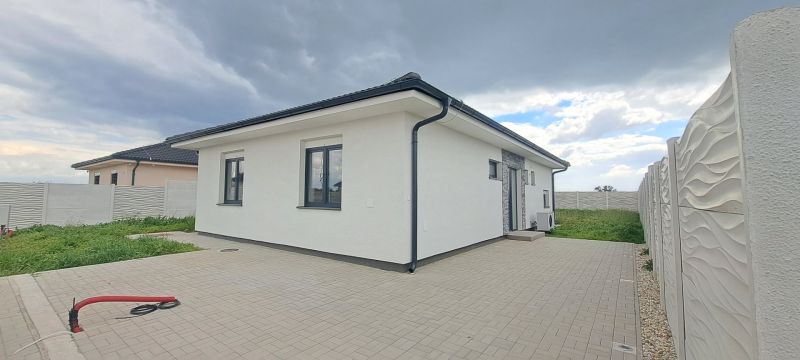 Rodinný dům v Topoľnici s bílou fasádou a dlážděným nádvořím.
