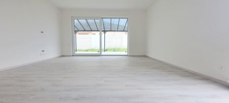 Prostorný světlý interiér s podlahou s dřevěným dekorem rodinného domu.