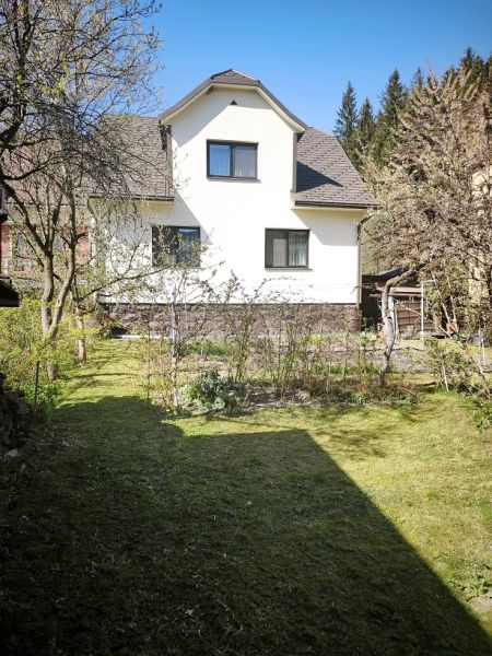 Rodinný dům ve Vysoké nad Kysucou obklopený udržovanou zahradou s trávníkem.
