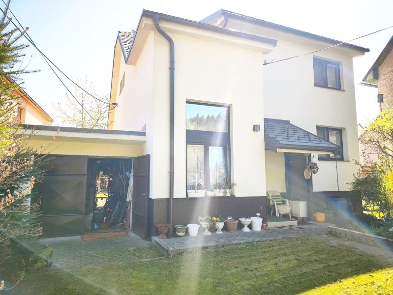 Rodinný dům ve Vysoké nad Kysucou s bílou fasádou a garáží.