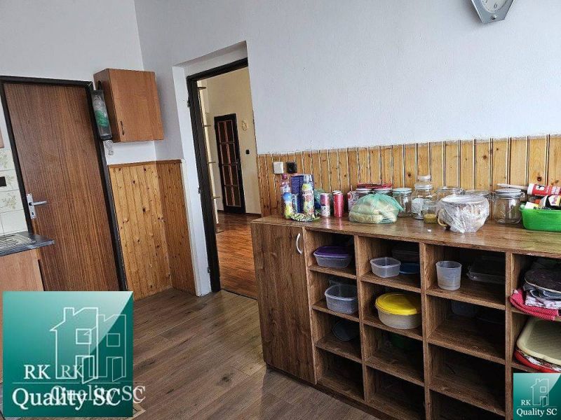 Kuchyně s dřevěným dekorem v rodinném domě s potravinami a skladovacími prostory.