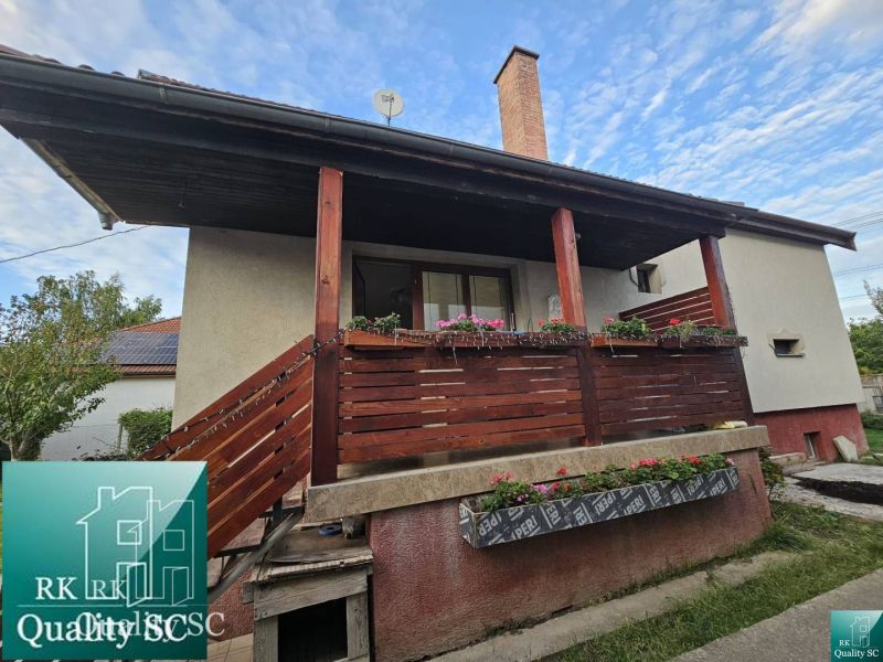 Rodinný dům na ulici v Turni má dřevěný balkón s květinovými ozdobami.