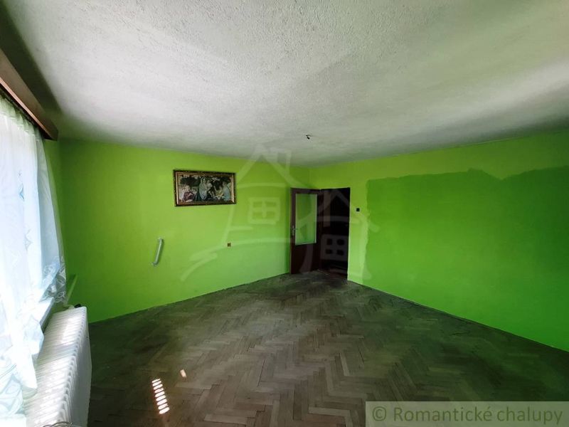 Zelené stěny v rodinném domě a podlaha s dřevěným dekorem.