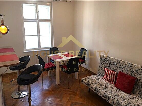 Jídelní kout ve 2-pokojovém bytě s podlahou s dřevěným dekorem a stylovým sezením.