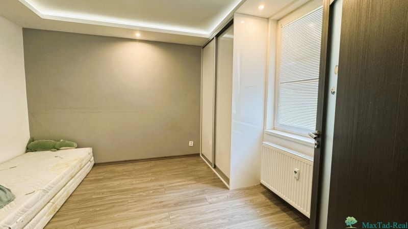 Interiér 4pokojového bytu s podlahou s dřevěným dekorem a vestavěnou skříní.