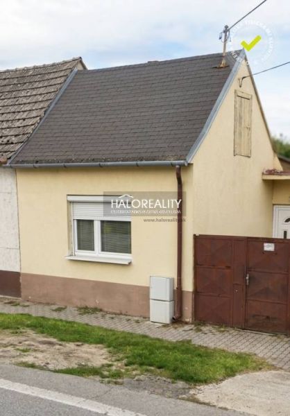 Rodinný dům v Malackách s malou předzahrádkou a jednoduchou fasádou.