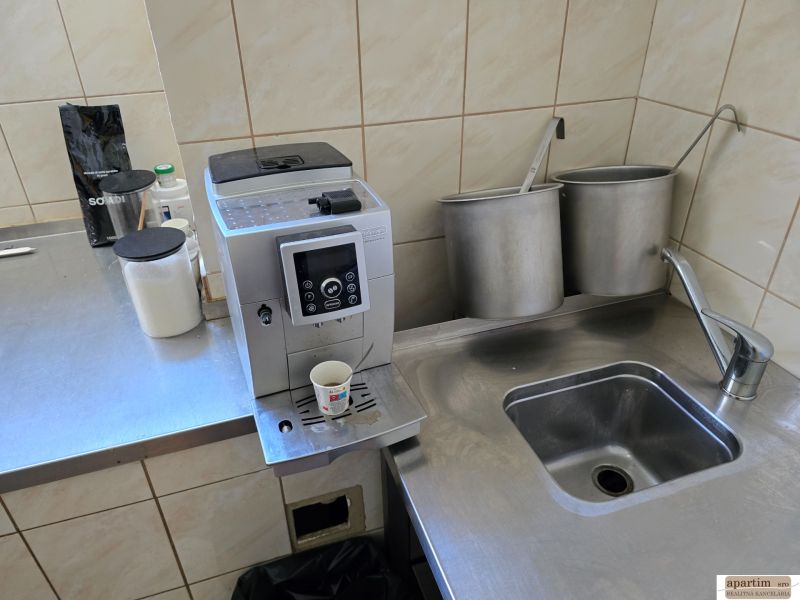 Kuchyňský kout s kávovarem, nerezovým dřezem a potřebami v gastro prostorech.