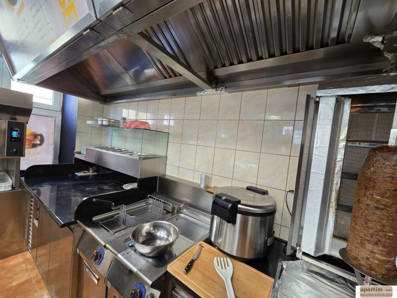 Kuchyňské zařízení v gastro prostorech s grilem a fritézou na přípravu jídel.