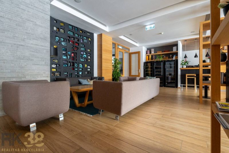 Obývací pokoj v rekreačním apartmánu s dekorativní stěnou a podlahou s dřevěným dekorem.