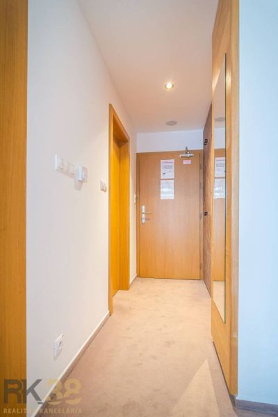 Chodba rekreačního apartmánu s dřevěnými prvky a kobercem.