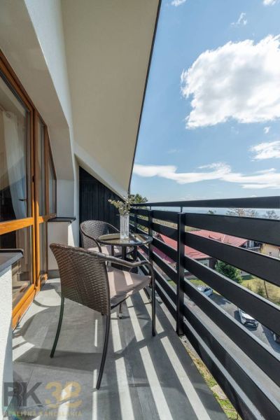 Balkon s ratanovým posezením a květinovou výzdobou ve 4-pokojovém bytě ve Vyšných Hágoch.