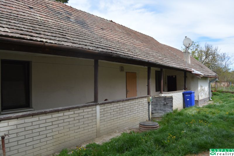 Exteriér rodinného domu v Horních Salibách se sedlovou střechou a cihlovým obkladem.