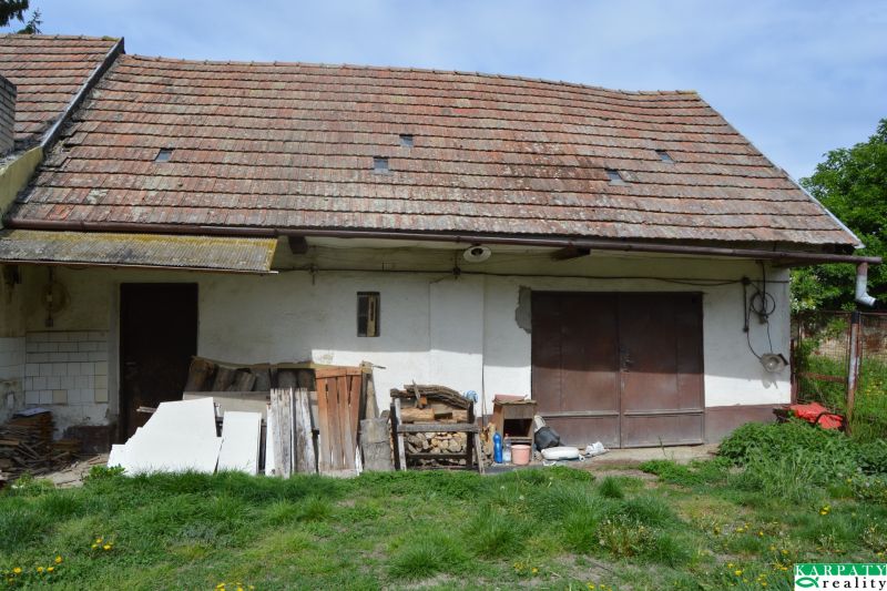 Rodinný dům v Horních Salibách se starou střechou a neudržovaným venkovním prostorem.