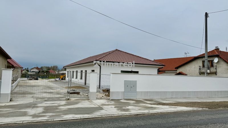 Rodinný dům na Hlavní ulici ve Vlčanech, bílá fasáda, červená střecha.