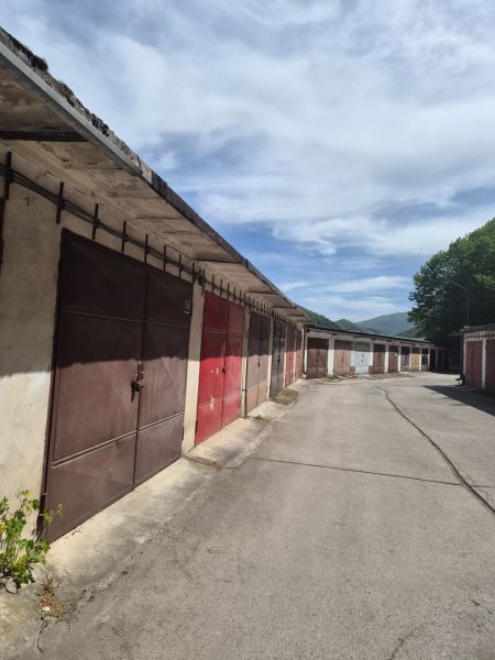 Garáže na ulici Čtvrť SNP v Trenčianských Teplicích pod modrou oblohou.