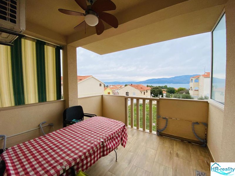 Rekreační apartmán na Brači: terasa s výhledem na moře a podlaha s dřevěným dekorem.