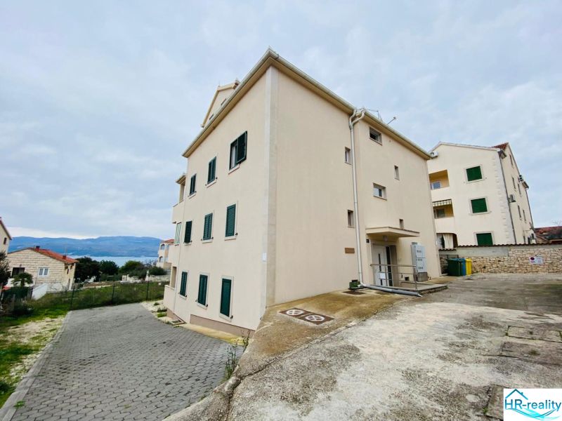 Rekreační apartmán na Brači se vstupem vedoucím z betonové příjezdové cesty.