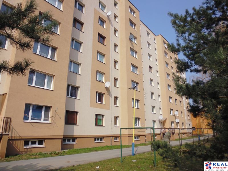 Bytový dům na ulici G.Svobody v Prešově, obklopený zelení a chodníkem.
