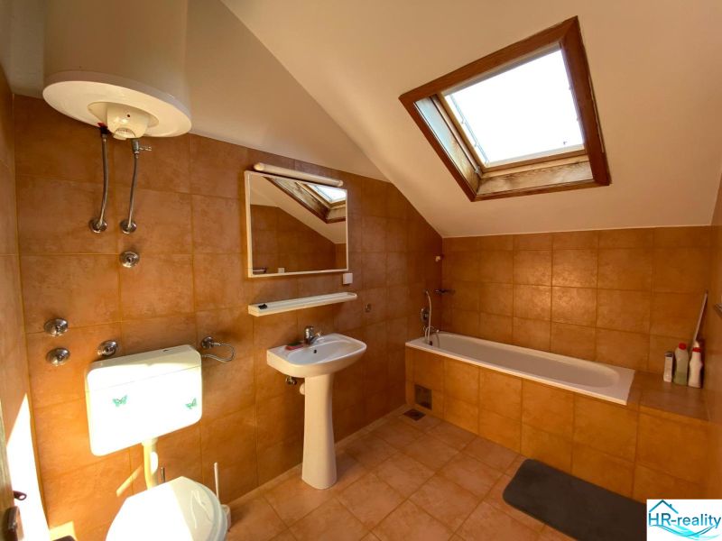 Koupelna v rekreačním apartmánu s vanou a střešním oknem.