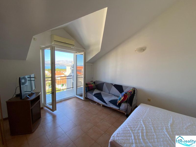 Pokoj v rekreačním apartmánu s balkónem a výhledem na moře, televizí a pohovkou.