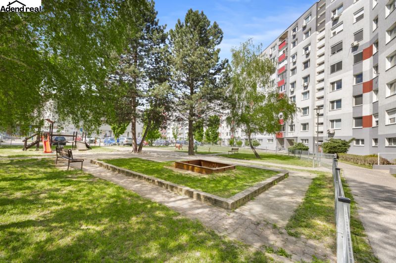 Dvůr plný zeleně s lavičkami a pískovištěm na Kríkové ulici, Bratislava - Vrakuňa.