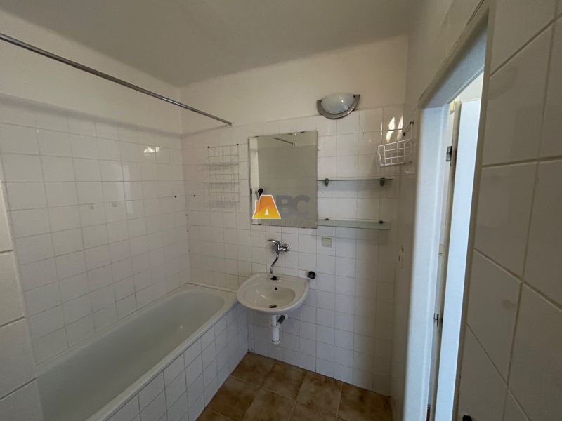 Koupelna s vanou v 2-pokojovém bytě s obkladovými dlaždicemi.