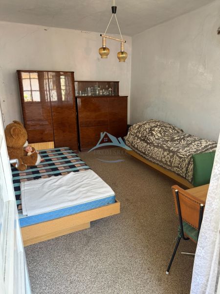 Pokoj s dvěma postelemi a skříňkou v rodinném domě.