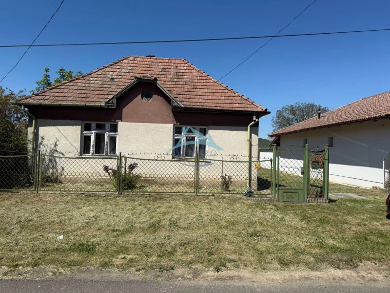 Rodinný dům v Honte má šikmou střechu a je oplocen kovovým plotem.