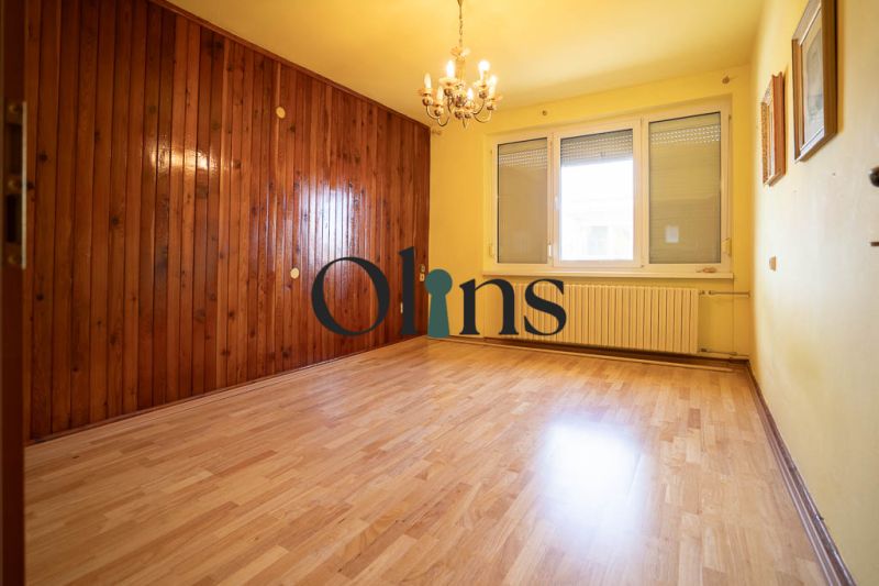 Pokoj s dřevěným obkladem a podlahou s dřevěným dekorem v rodinném domě.