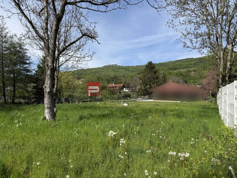 Pozemky na bydlení v Borince s výhledem na zeleň a okolní kopce.