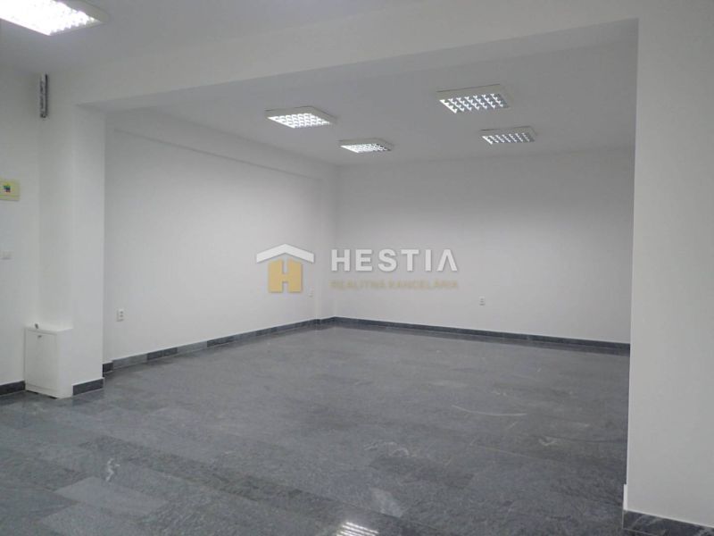Prostorná místnost s bílými stěnami a podlahou s kamenným vzhledem v Pozemky - komerční.