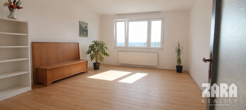 Obývací pokoj se světlou podlahou s dřevěným dekorem a rostlinami ve 4-pokojovém bytě.
