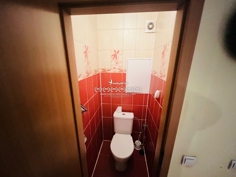 Toaleta s červenými kachličkami v 3-pokojovém bytě.