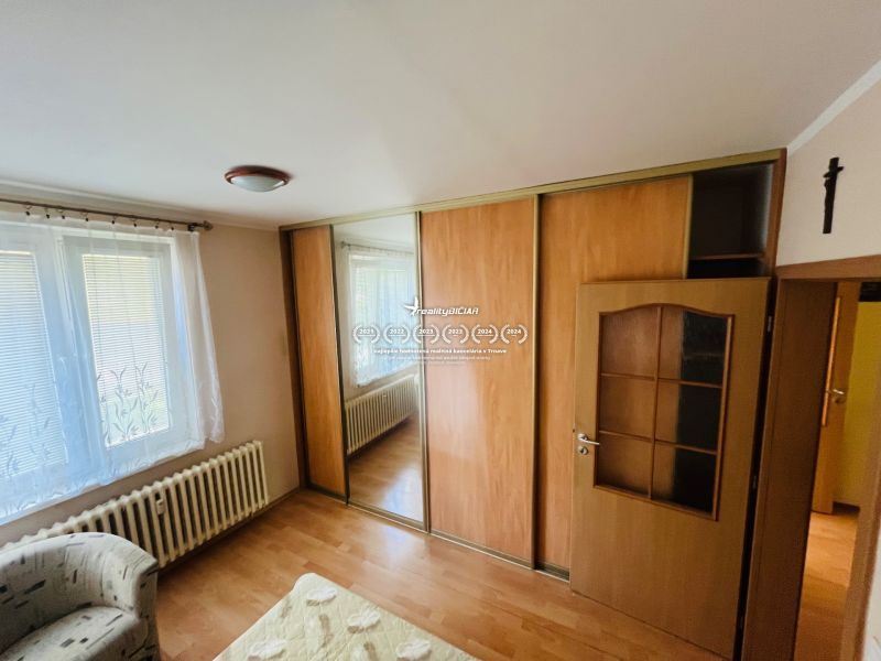 Bílá stěna, skříň s posuvnými dveřmi, podlaha s dřevěným dekorem, 3-pokojový byt.