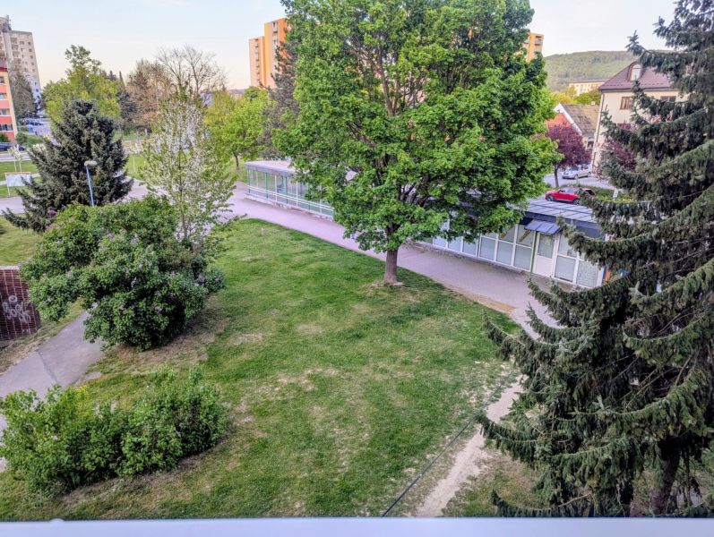 Zeleň v okolí ulice Centrum I v Dubnici nad Váhom s chodníky a budovami.