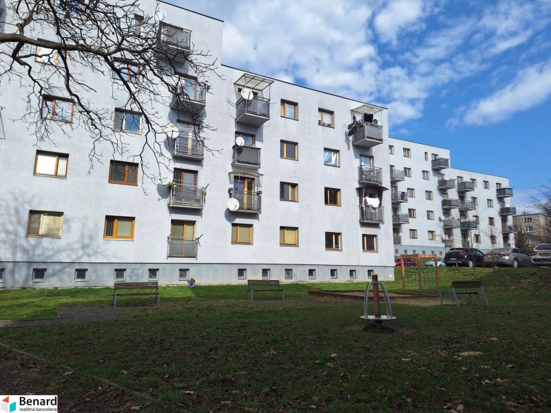Bytový dům na ulici Majakovského v Prešově obklopený zelení a parkovištěm.