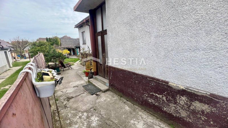 Dvůr rodinného domu v Cerové se zelení a zahradním nábytkem.