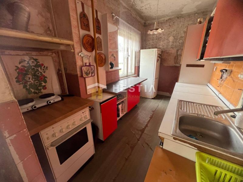 Kuchyně v rodinném domě s podlahou s dřevěným dekorem a retro nábytkem.