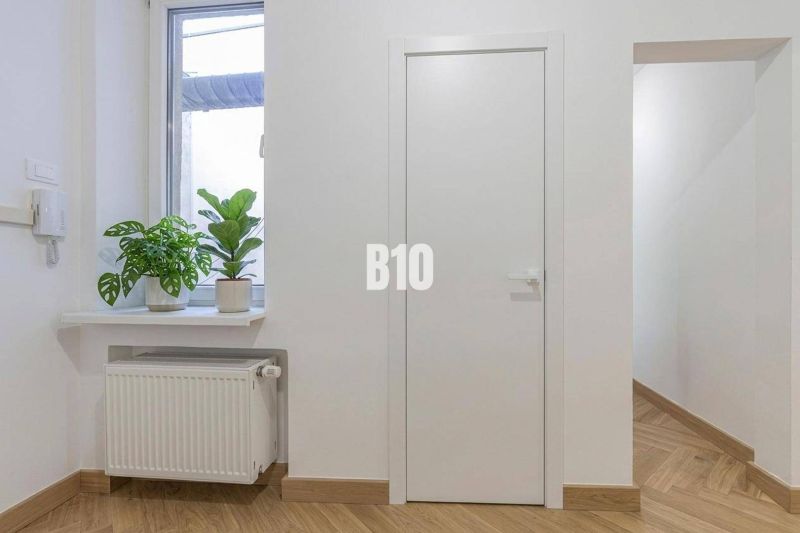Interiér 3-pokojového bytu s rostlinami na parapetu a podlahou s dřevěným dekorem.