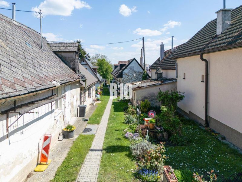 Úzký průchod se zahradou a staršími domy na ulici Jadranská v Bratislavě IV. Pozemky - bydlení.