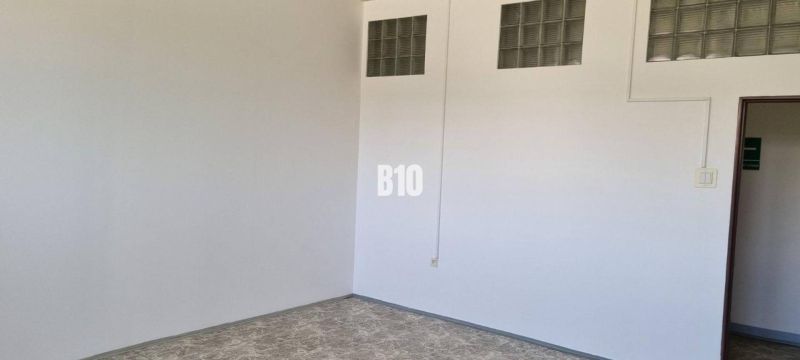 Bílá stěna se skleněnými tvárnicemi, podlaha s dřevěným dekorem, obchodní prostory.