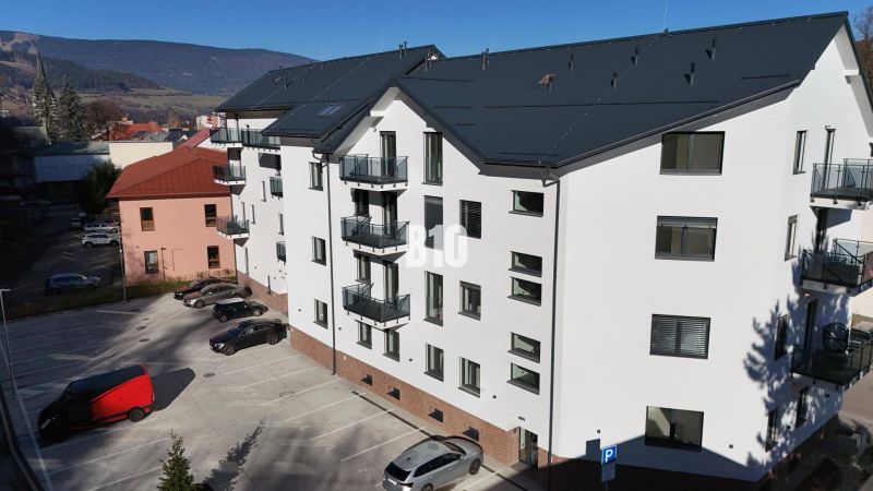 Budova s bílou fasádou a parkovištěm na Matúškově ulici v Dolním Kubíně, kanceláře.