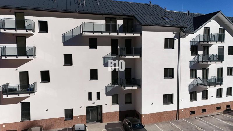 Fasáda bytového domu v Dolním Kubíně s parkovištěm a balkóny, ideální pro 2-pokojový byt.