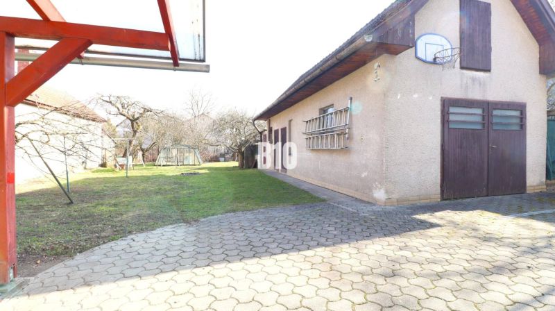 Dvůr rodinného domu v Turanech s garáží a basketbalovým košem.