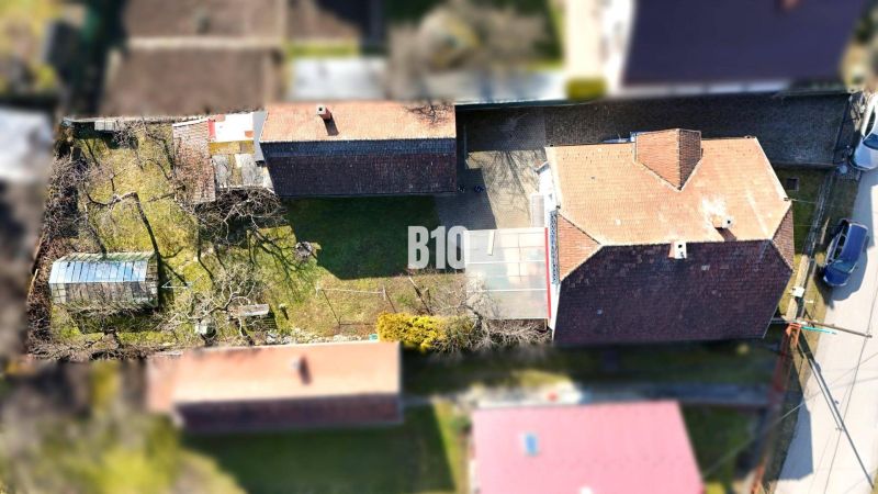Letecký pohled na rodinný dům v Turanech s dvorem a skleníkem.