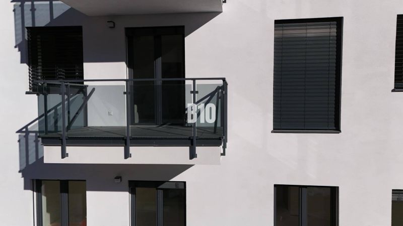 Balkon se zaskleným zábradlím a okenicemi na budově dvoupokojového bytu v Dolním Kubíně.