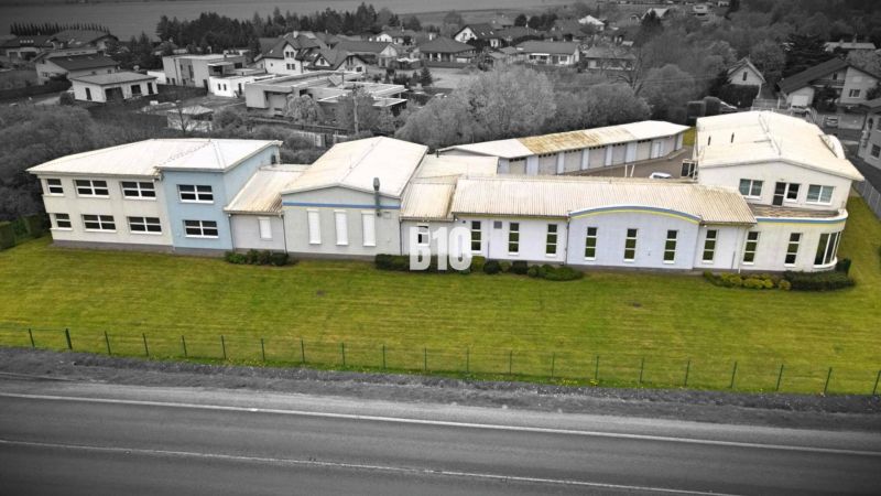 Výrobní prostory v Košťanech nad Turcem s rozlehlou zelenou plochou v průmyslové zóně.