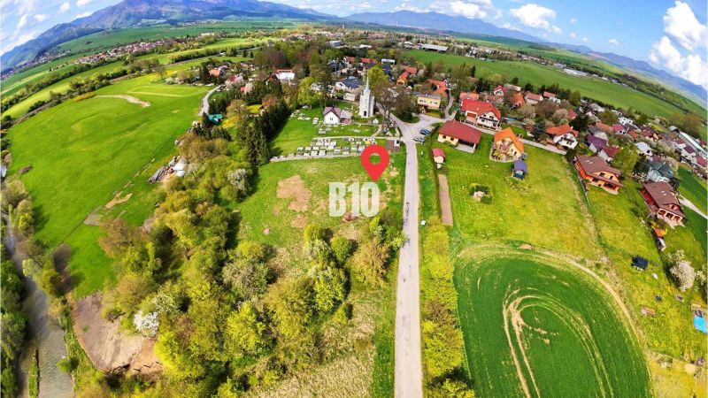 Letecký pohled na venkovský pozemek k bydlení s přírodním prostředím a roztroušenými domy.