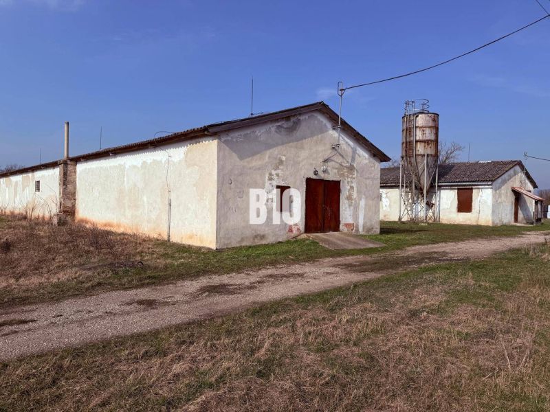 Výrobní prostory v Turej s zemědělskou architekturou a silem na pozadí.